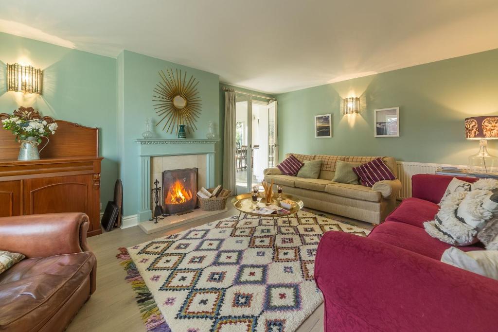 uma sala de estar com um sofá e uma lareira em Owl Cottage Woodside em Burnham Market