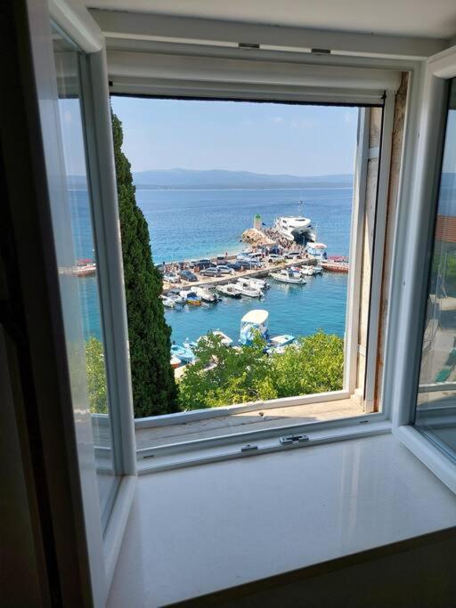 a window with a view of a marina at Centrum Bol Apartment - One Minute from the Sea in Bol