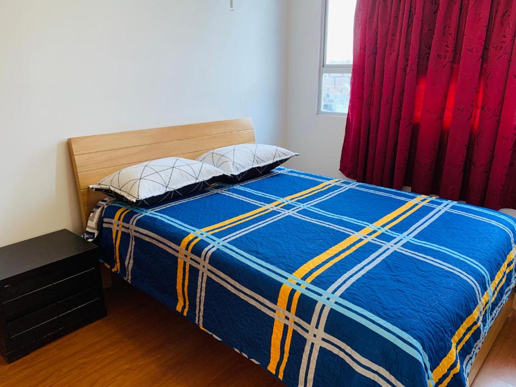 ein Schlafzimmer mit einem Bett mit einer blauen und gelben Decke in der Unterkunft Bogotá Kings 401 in Bogotá