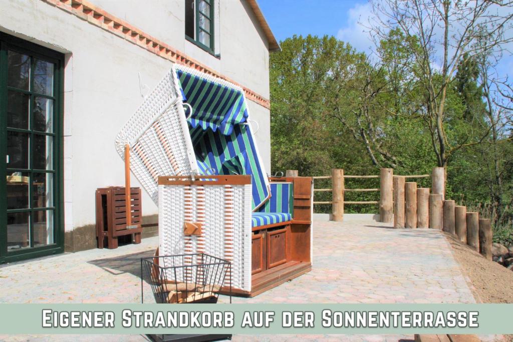una mecedora azul y blanca fuera de una casa en Landhaus Ankerplatz- Ferien2024 an der Ostsee, fernab vom Mainstream bei Bad Doberan, en Gorow