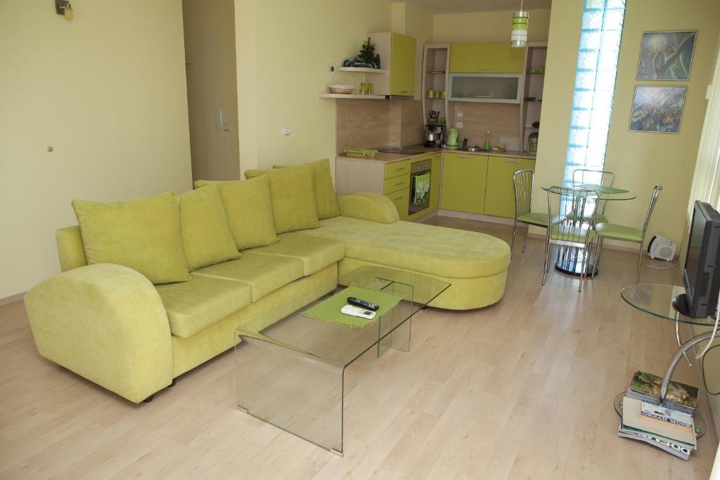 a living room with a yellow couch and a kitchen at Spa Villa Crystal in Hisarya