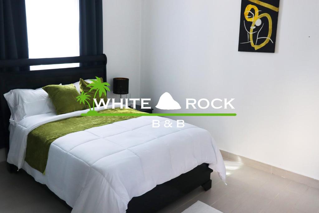 a bedroom with a bed with a white rock sign on it at The White Rock Hotel B&B in Los Conucos