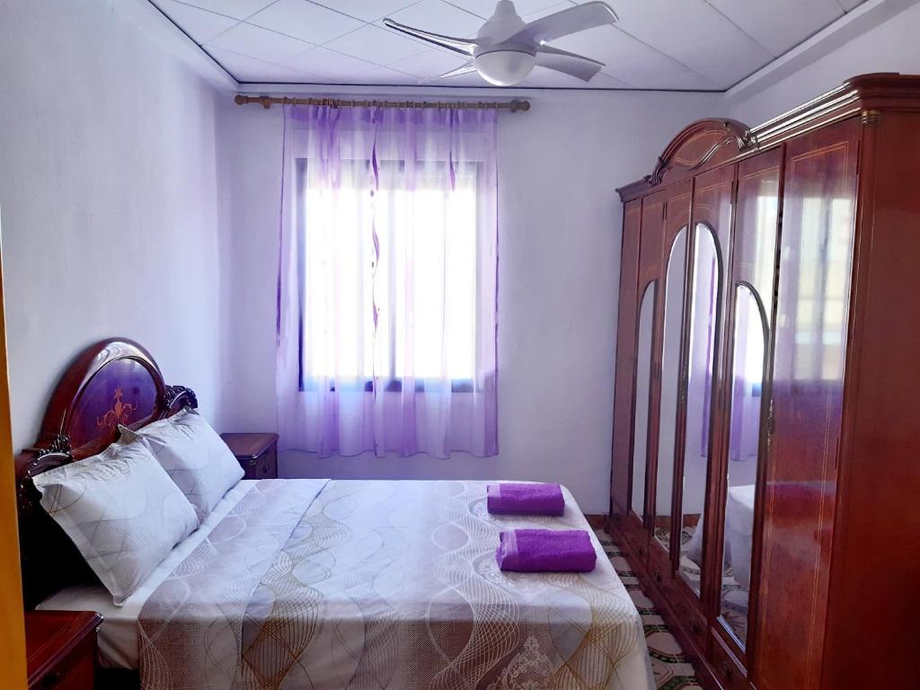 a bedroom with a bed with purple pillows on it at Apartamento Vernissa in Gandía