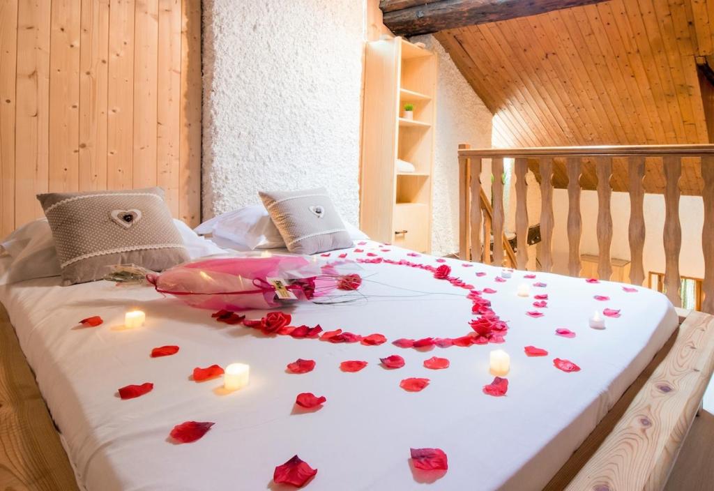 un lit avec un bouquet de roses sur le lit dans l'établissement Perle du lac au coeur de la vieille ville, à Annecy