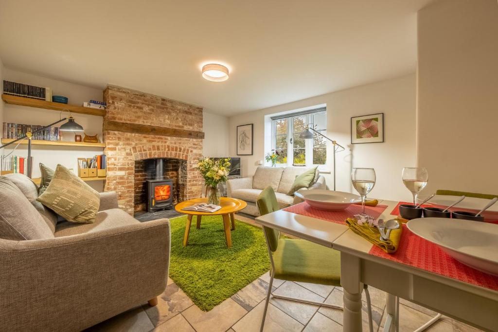 a living room with a couch and a fireplace at Chiffchaff Cottage in West Raynham