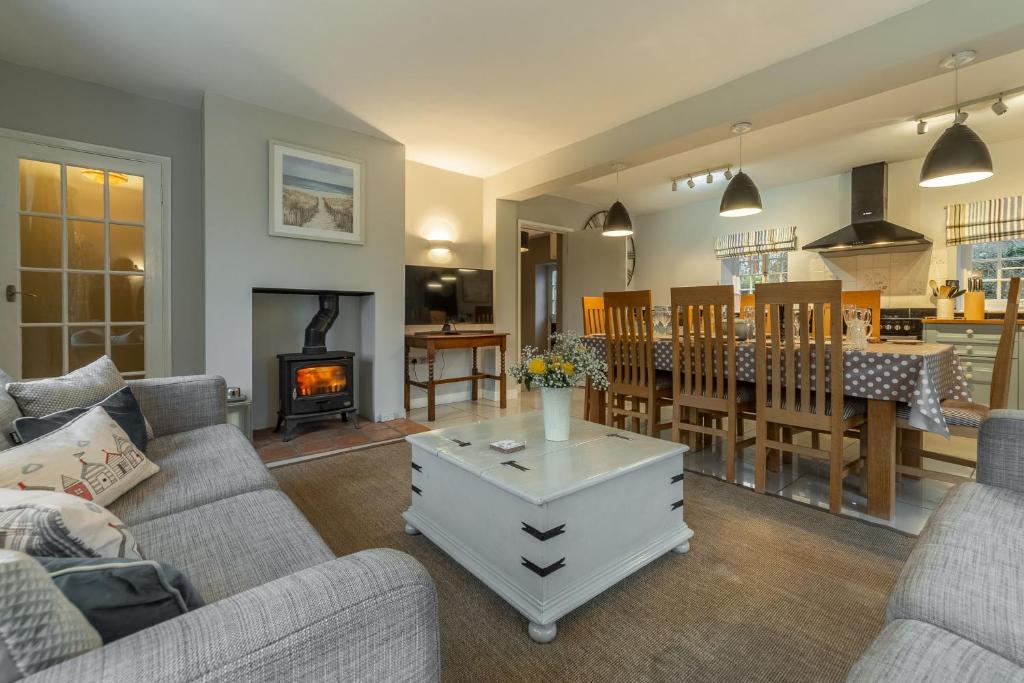 a living room with a couch and a dining room at 2 Dix Cottages in Thornham