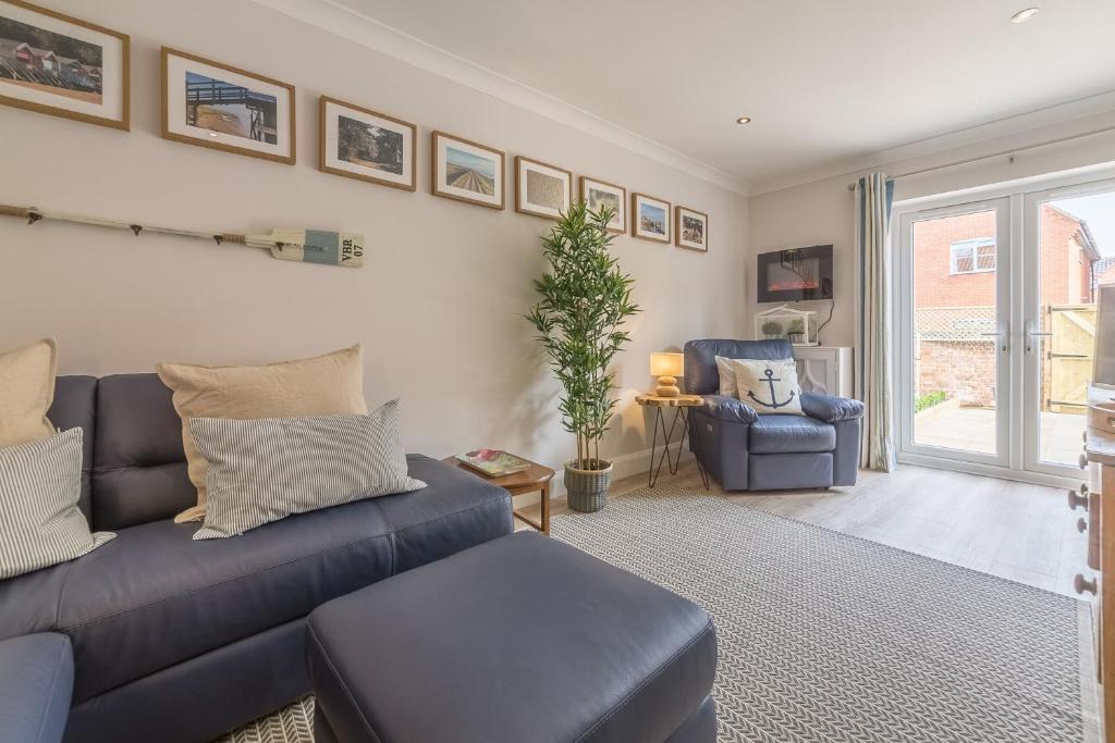 a living room with a blue couch and a chair at Kipling House 8 in Wells next the Sea