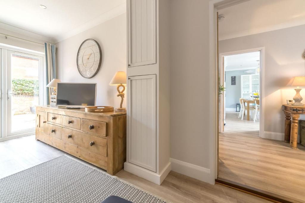 a living room with a television on a wooden dresser at Kipling House 8 in Wells next the Sea