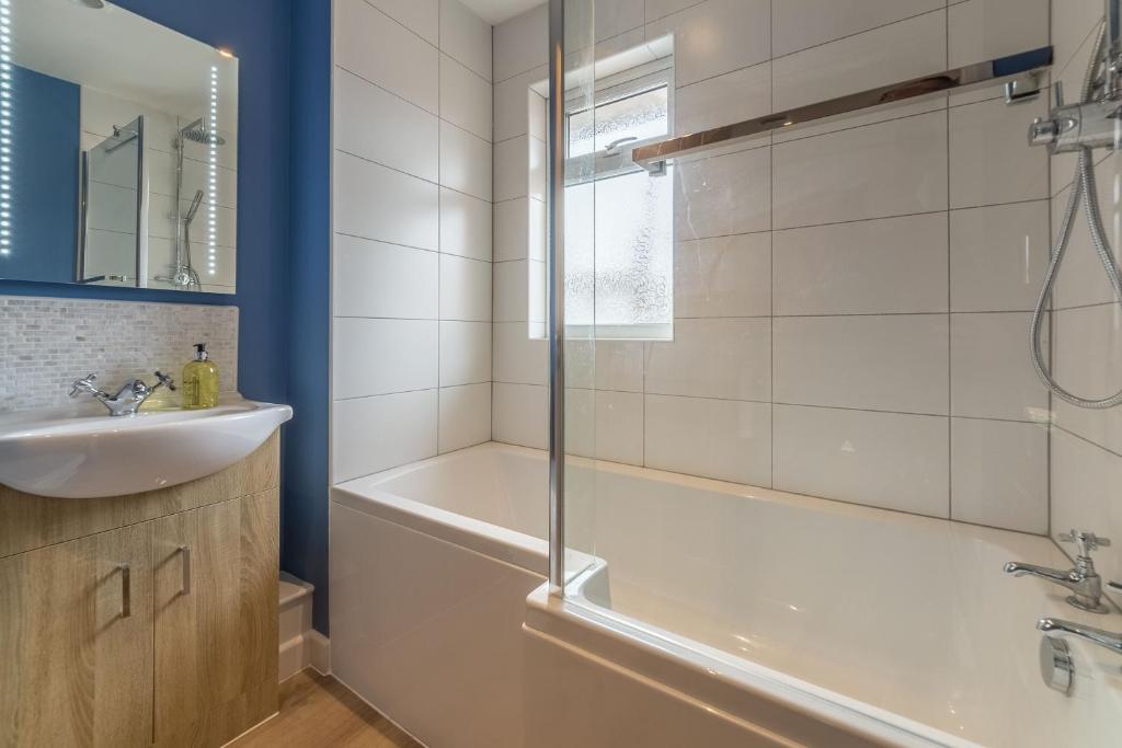 a bathroom with a tub and a sink at Kipling House 8 in Wells next the Sea