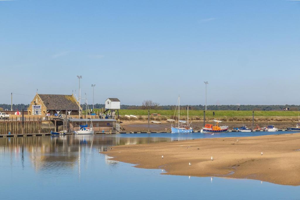 a marina with boats on the sand and a house at Kipling House 8 in Wells next the Sea