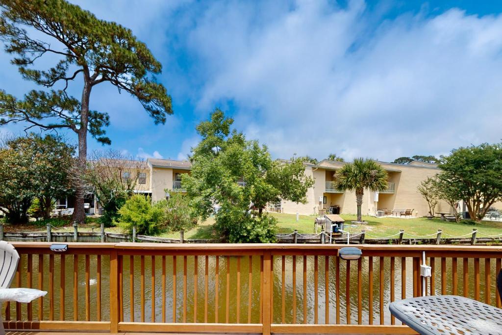 a deck with a wooden fence and a table and chairs at Gulf Highlands Grande Island Blvd in Panama City Beach