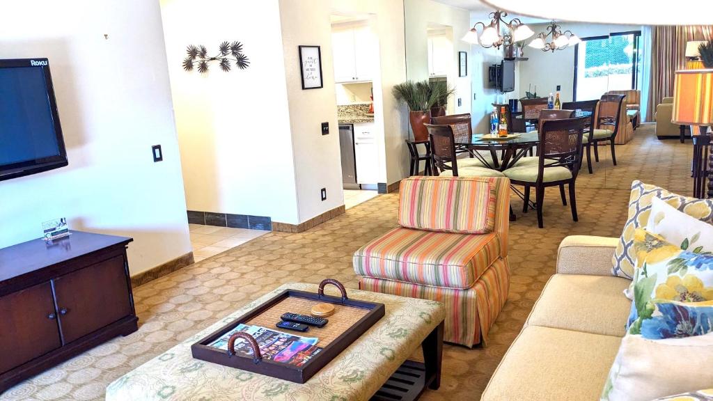 a living room with a couch and a tv and a table at Upscale 2Bed 2Bath Condo Prime Location WiFi Pools Kitchen Security in Palm Springs