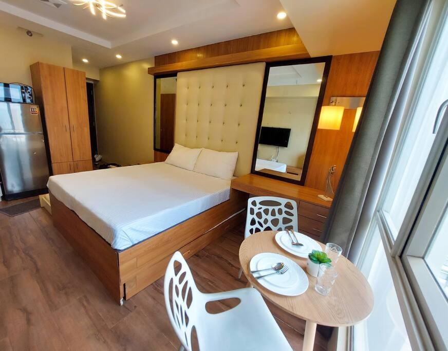 a bedroom with a bed and a table and chairs at Centrio Tower w/ Netflix + WiFi in Cagayan de Oro