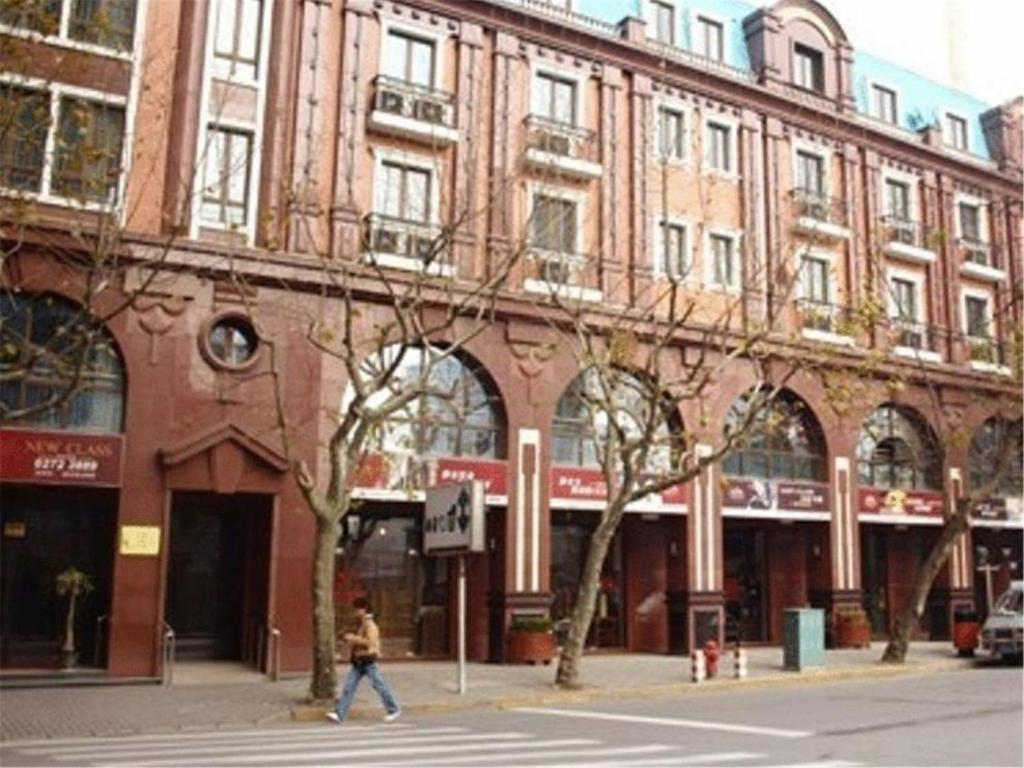 a person walking on a street in front of a building at Ladoll Service Apartments in Shanghai