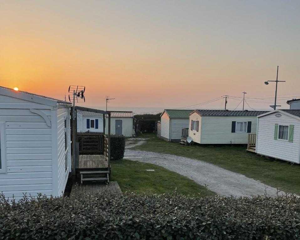 a row of mobile homes with the sunset in the background at Mobil-Home VUE sur MER in Le Portel