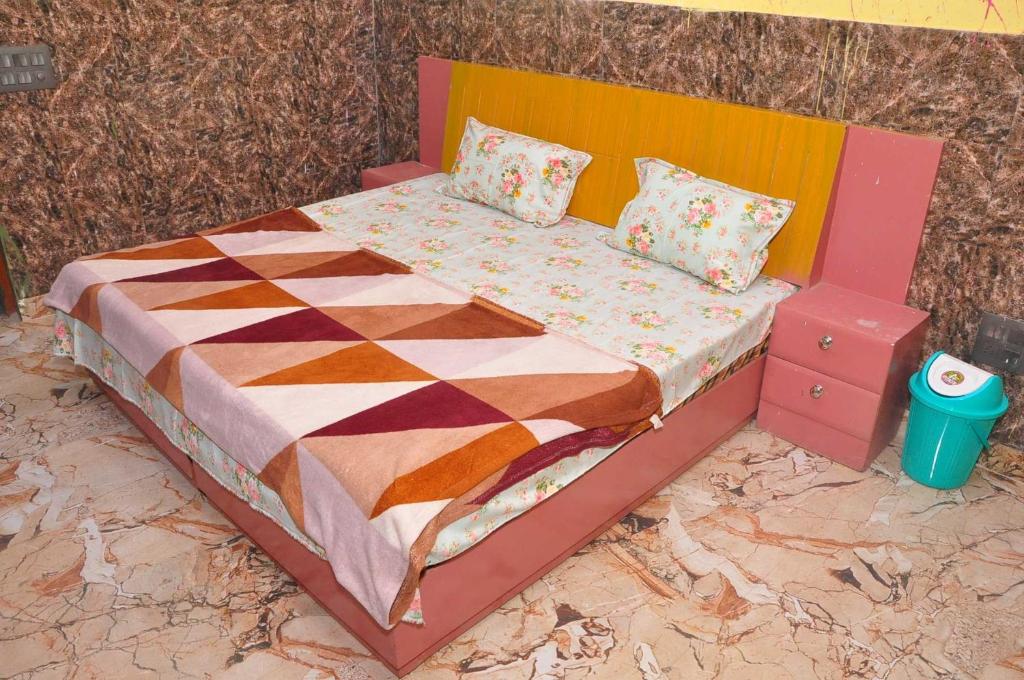 a bed with a colorful comforter and pillows on it at Hotel O Grand in Alīgarh