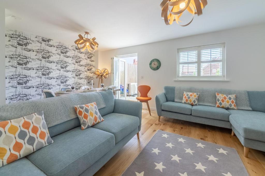 a living room with two blue couches at Lavandula 4 in Burnham Market