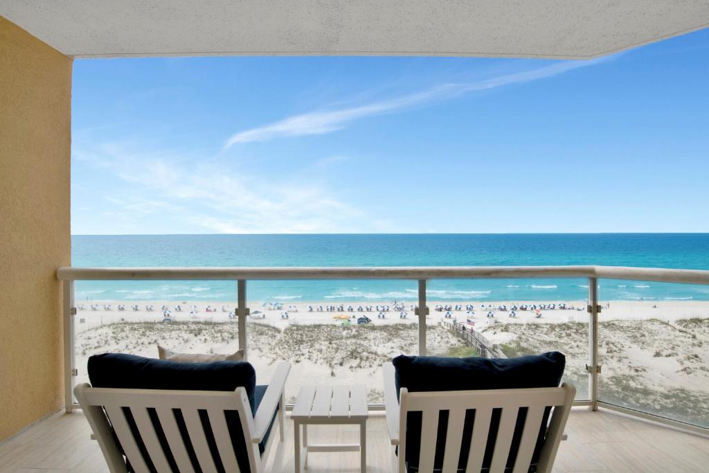 einen Balkon mit Stühlen und Strandblick in der Unterkunft Emerald Isle #602 in Pensacola Beach