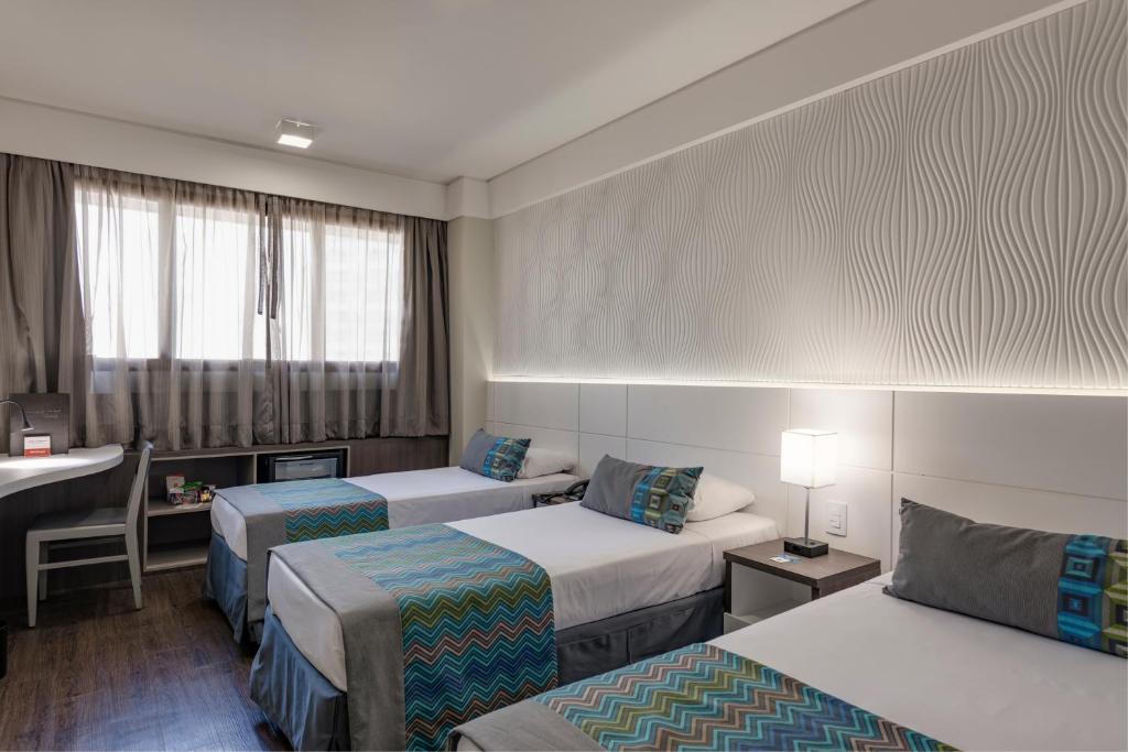 Uma cama ou camas num quarto em Monreale Plus Midtown Campinas