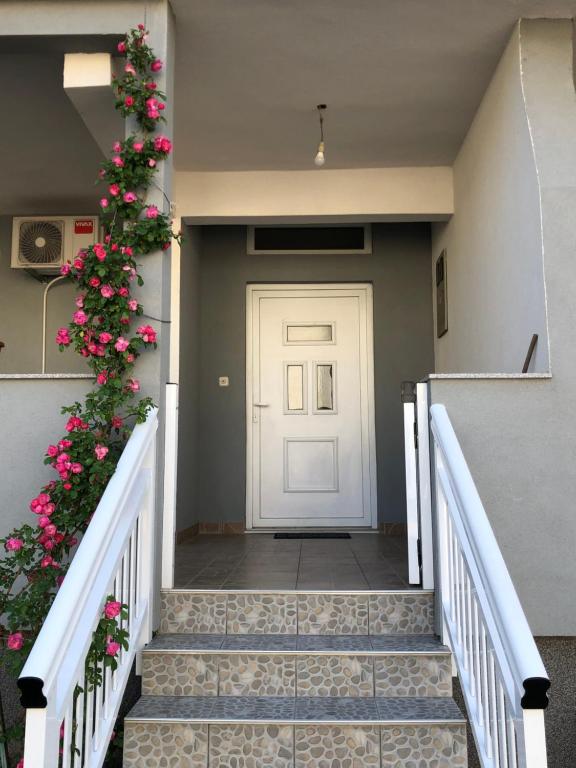 a door with a christmas wreath and stairs with flowers at Apartment Hercegovina in Mostar