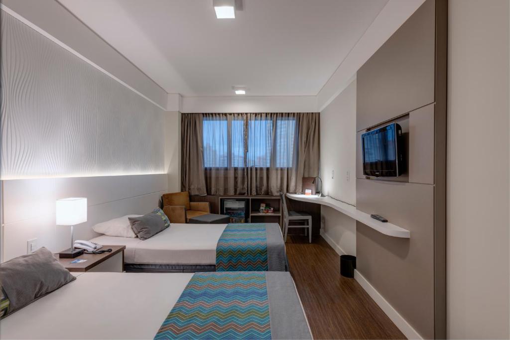 Uma cama ou camas num quarto em Monreale Plus Midtown Campinas