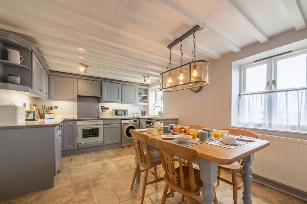 a kitchen with a table and a dining room at Creek Cottage in Wells next the Sea