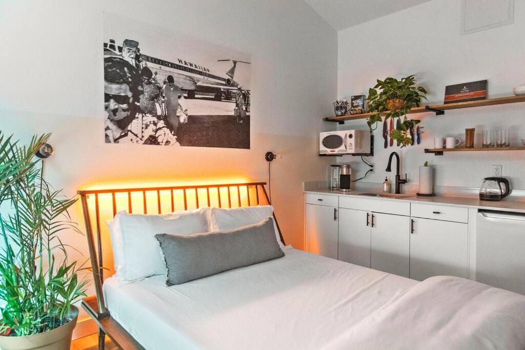 a small bedroom with a bed and a kitchen at Puāukiʻi Studio suite liʻiliʻi in Chandler