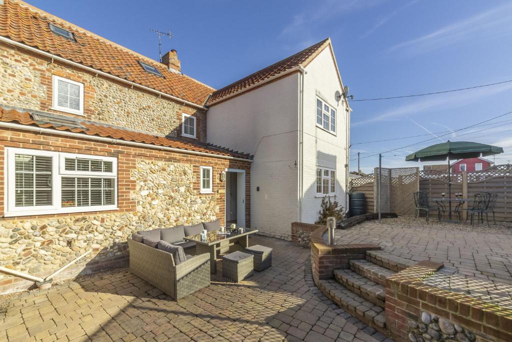 a patio of a house with a table and chairs at Coxswains House 4 in Wells next the Sea