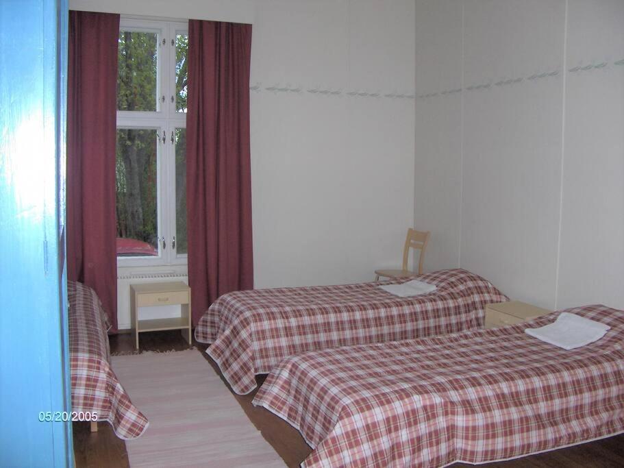 um quarto de hotel com duas camas e uma janela em Maaseutumajoitus, Kesti-Iivarin Majatalo em Ylistaro
