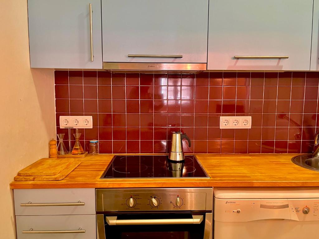 a kitchen with a sink and a stove top oven at Apartamento Tramuntana de Portbou in Portbou