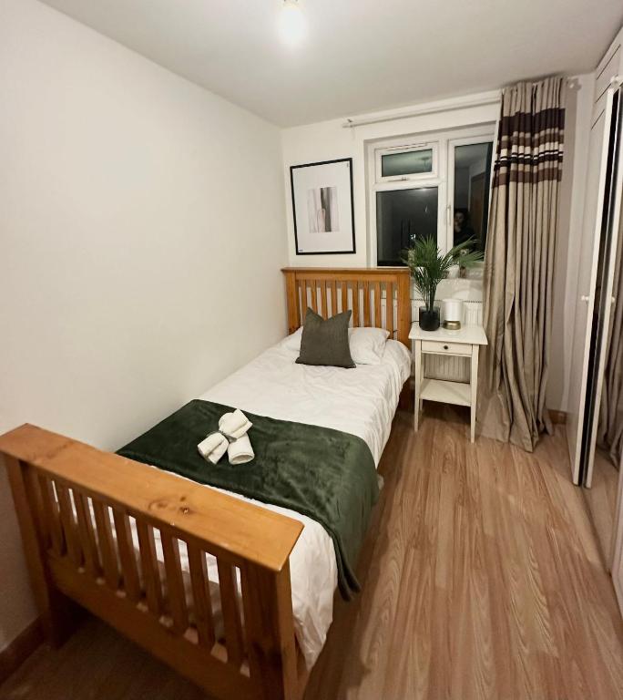 ein Schlafzimmer mit einem Bett mit einem Band darauf in der Unterkunft Relaxing Room in Spacious House in London