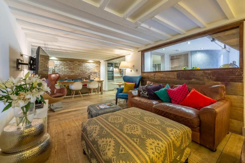a living room with a couch and a table at Hideaway Barn 4 in Thornham