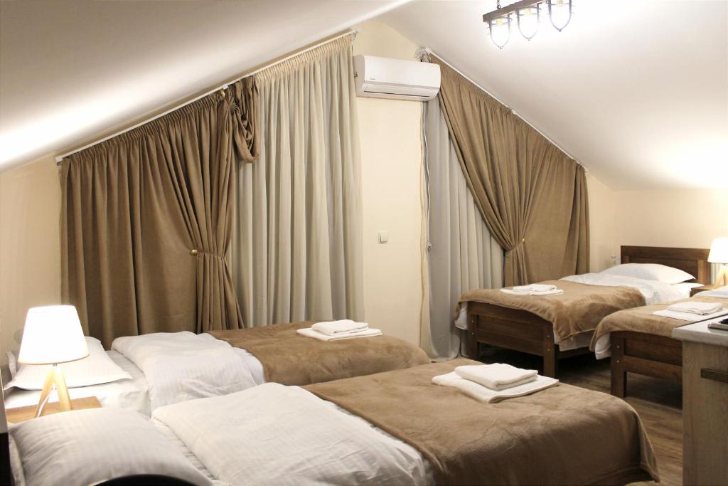 ein Hotelzimmer mit 3 Betten und Handtüchern darauf in der Unterkunft Nitsa Guest House in Gori