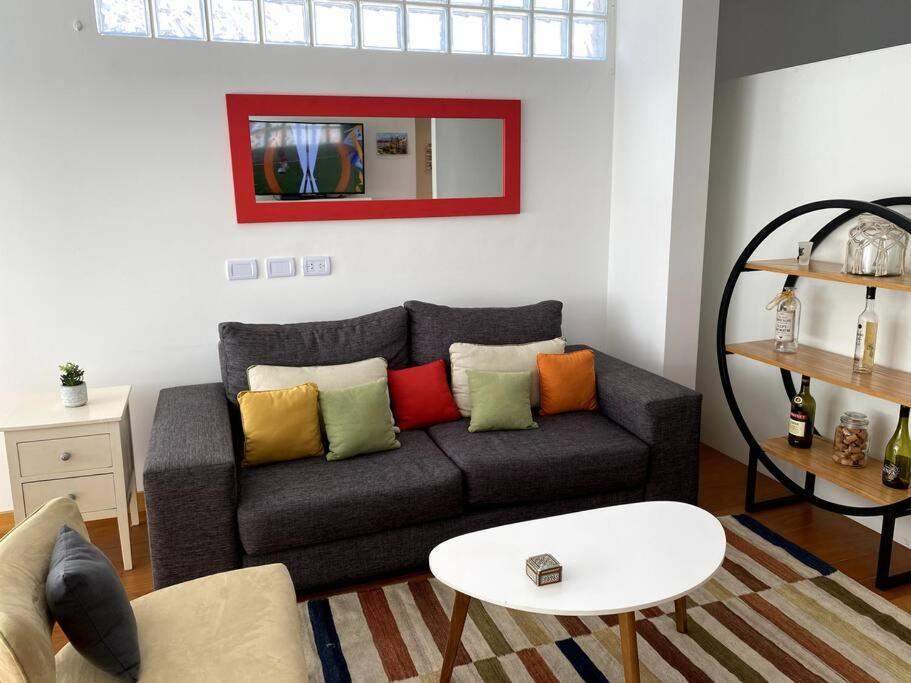 sala de estar con sofá y almohadas coloridas en Hermoso Studio en Recoleta con Piscina y Laundry en Buenos Aires