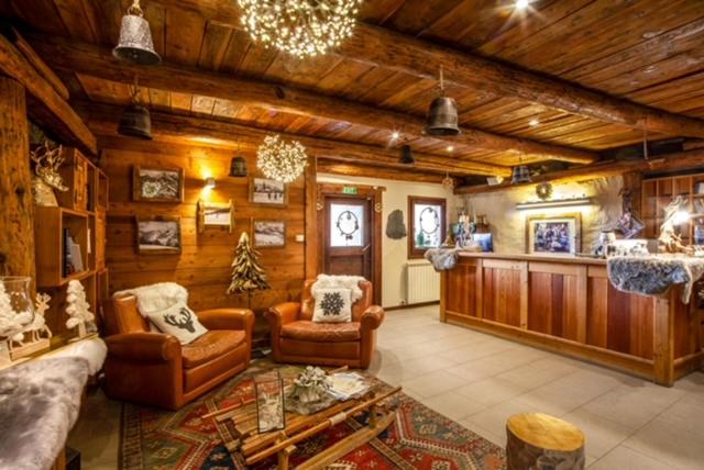 a living room with a couch and chairs in a house at Chalet Faure in Sauze dʼOulx