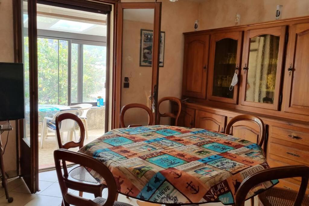 une salle à manger avec une table sur laquelle est posée une courtepointe dans l'établissement maison rez de jardin 2 à 4 personnes, au Lavandou