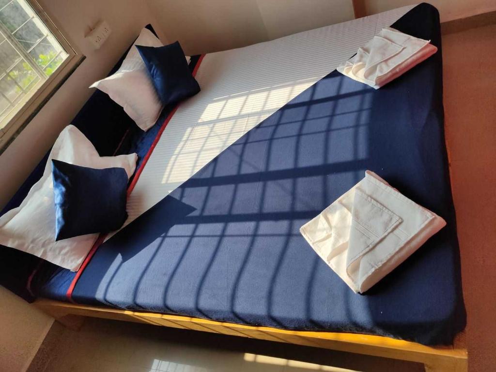 een bed met blauwe lakens en kussens erop bij Hotel Chalukya Executive in Pune