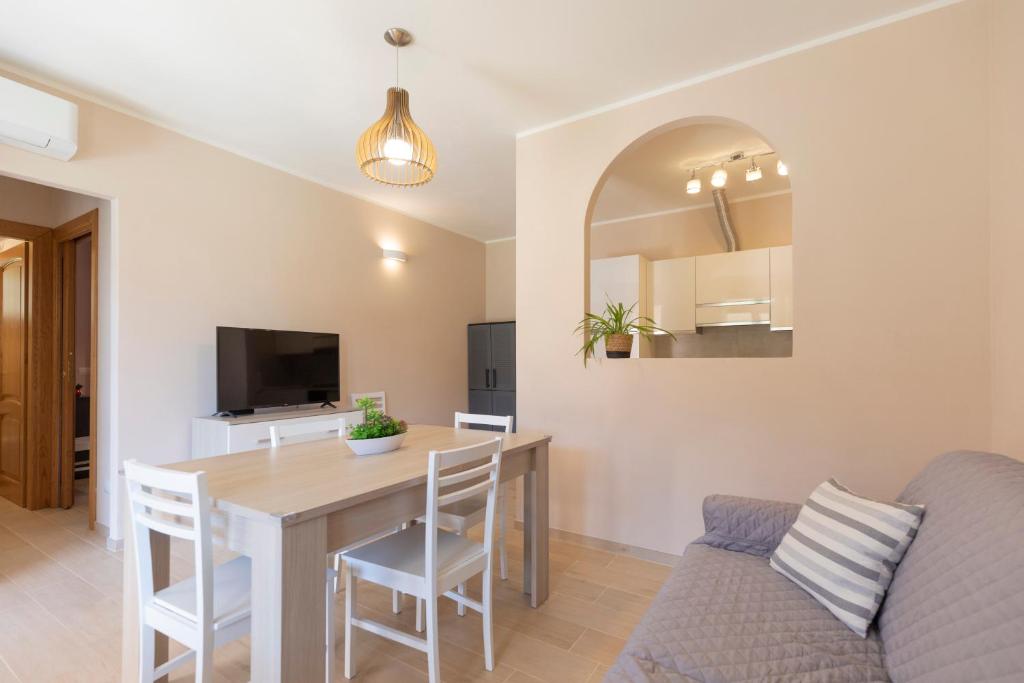 a dining room and living room with a table and a couch at Villa dei Pini Capoliveri in Capoliveri