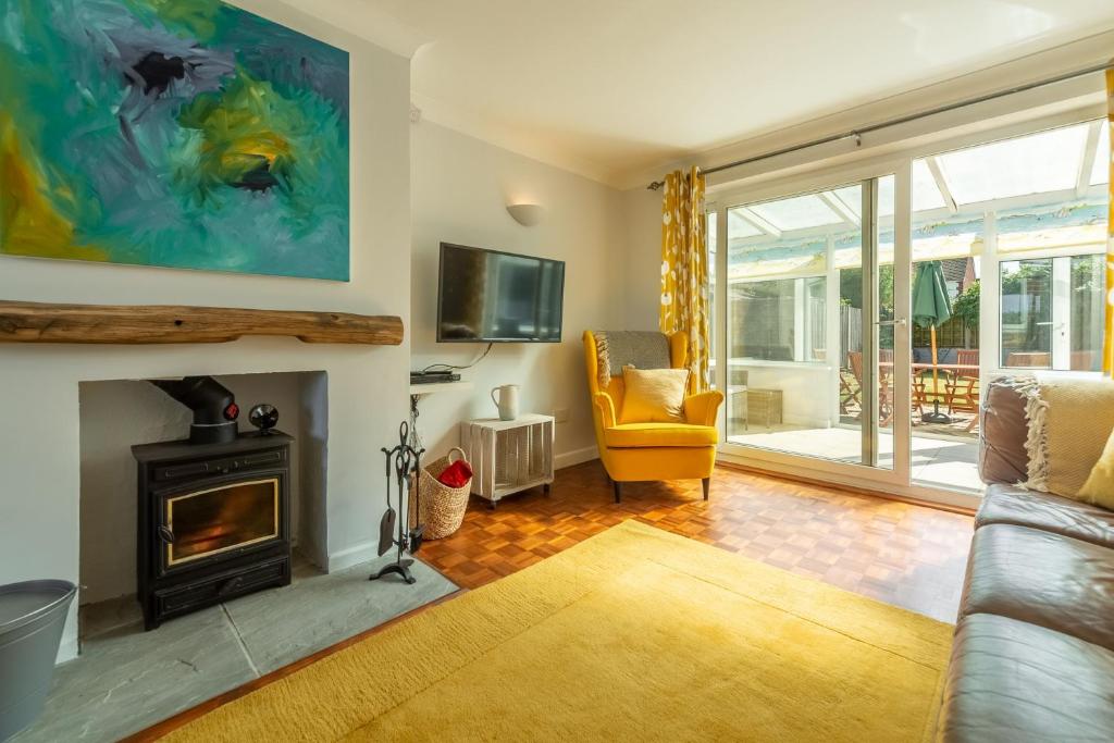 a living room with a fireplace and a yellow chair at High View in Wells next the Sea