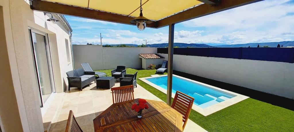 Elle offre une vue sur une terrasse avec une piscine. dans l'établissement Villa neuve avec piscine chauffée dans le Lubéron, à Villeneuve