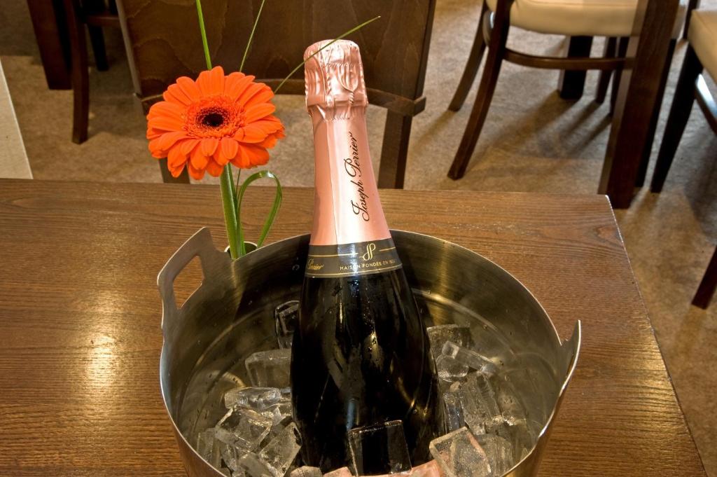 a bottle of champagne in a bucket with a flower at New Dungeon Ghyll Hotel in Great Langdale