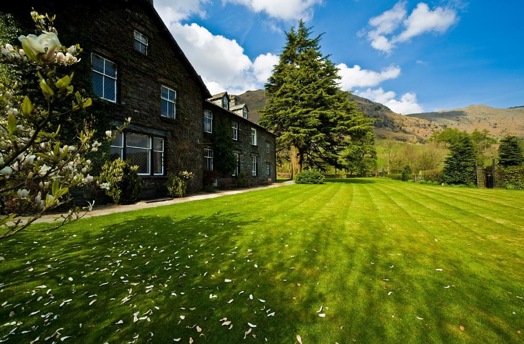 a large grass field in front of a building at New Dungeon Ghyll Hotel in Great Langdale