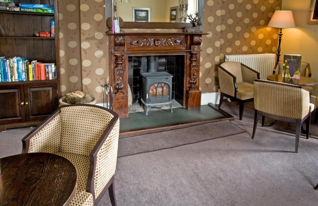 a living room with a fireplace and a table and chairs at New Dungeon Ghyll Hotel in Great Langdale