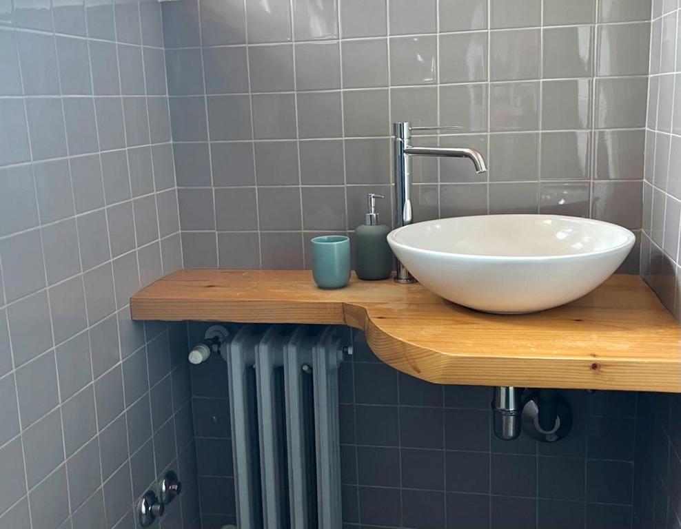 baño con lavabo blanco en una encimera de madera en Malvezzi 36, en Fano