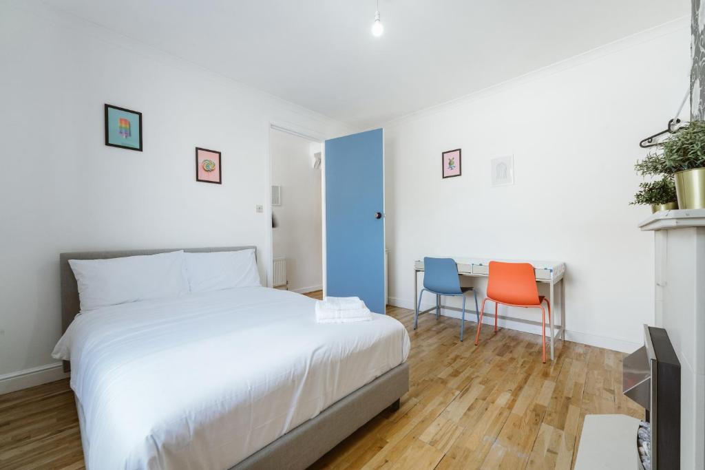 a bedroom with a bed and a table and chairs at Great Rooms in Stepney Green Station - 12 in London
