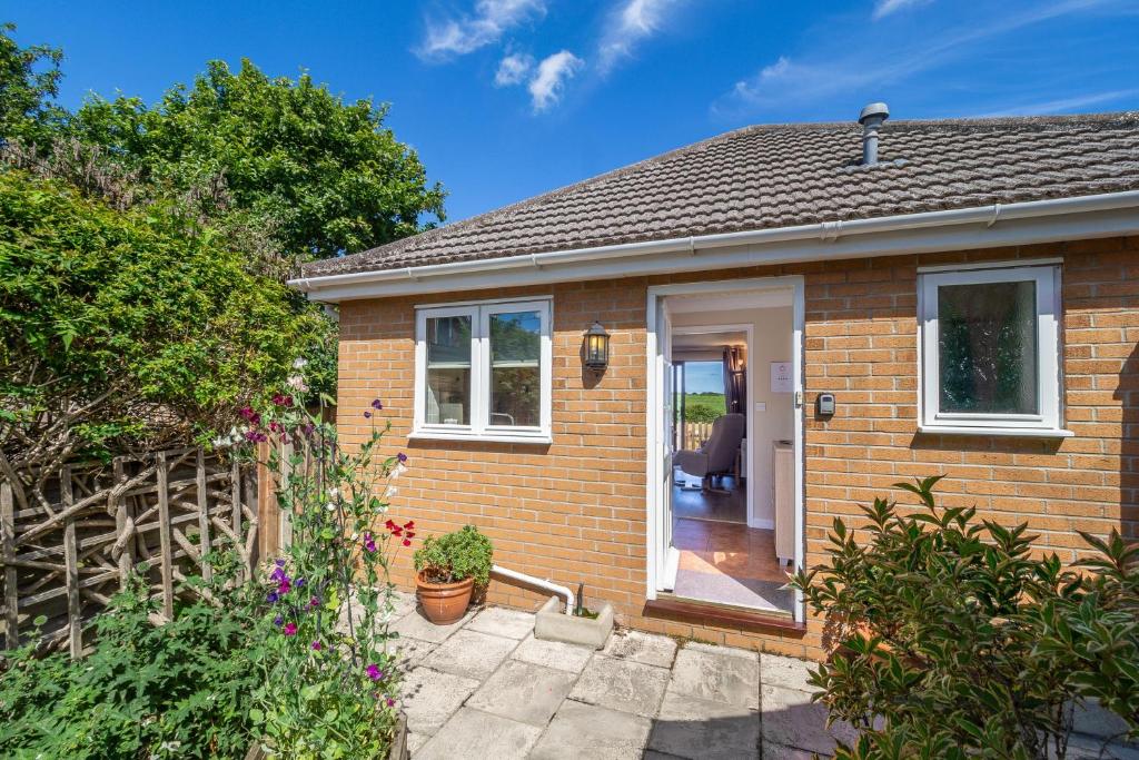 a small brick house with a white door at Little Emmaus in Cley next the Sea