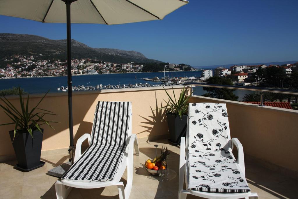 2 sillas sentadas en un balcón con sombrilla en Apartment One Vision en Split