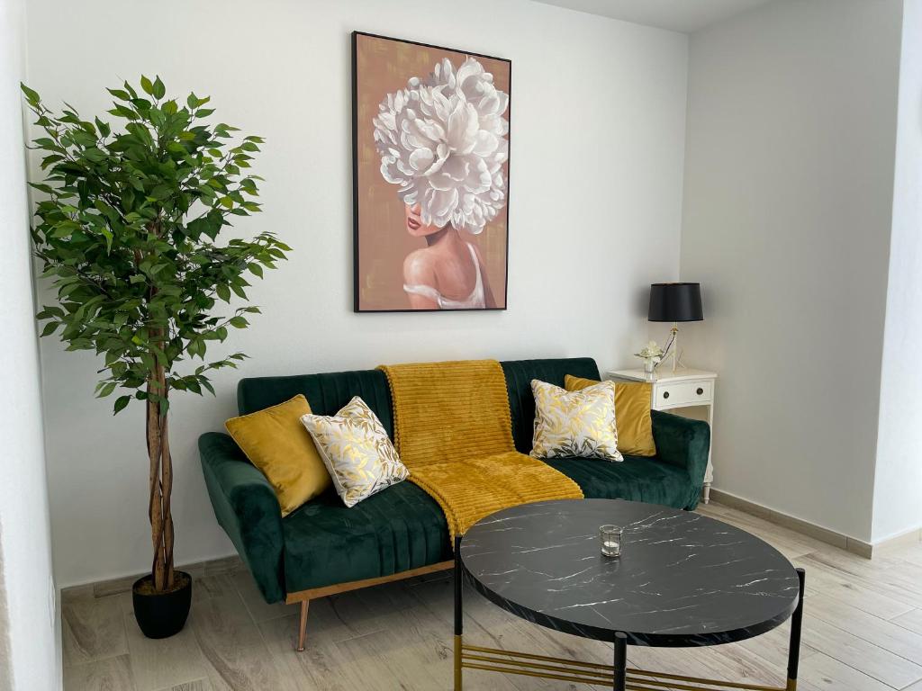 een woonkamer met een groene bank en een tafel bij Our Charming House in Portimão