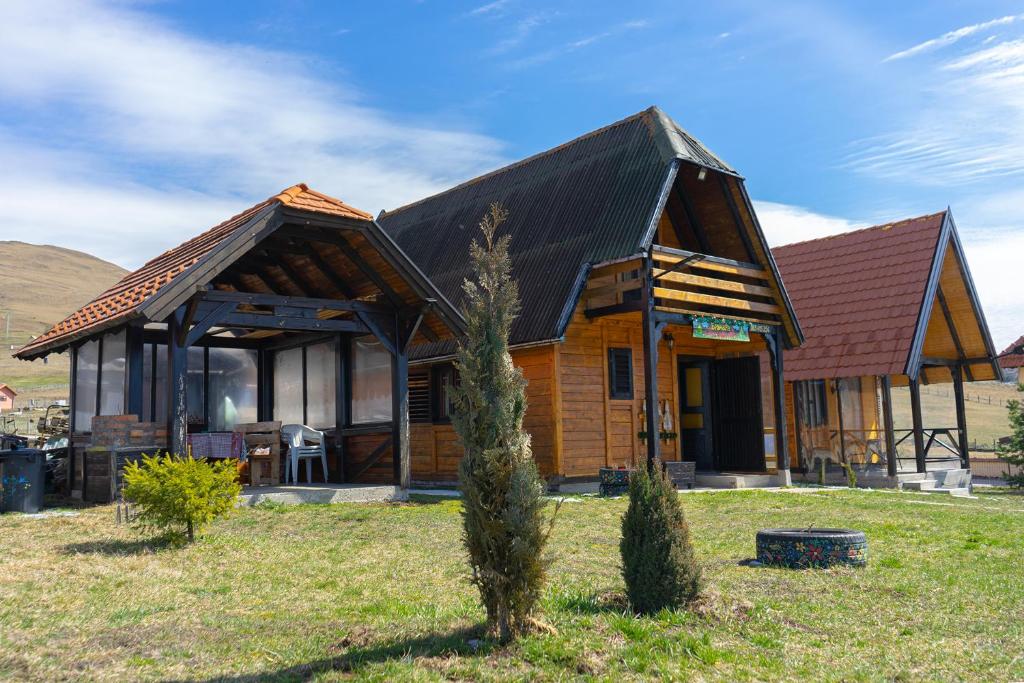 una casa de madera con un árbol delante en Brvnara Zlatiborka en Zlatibor