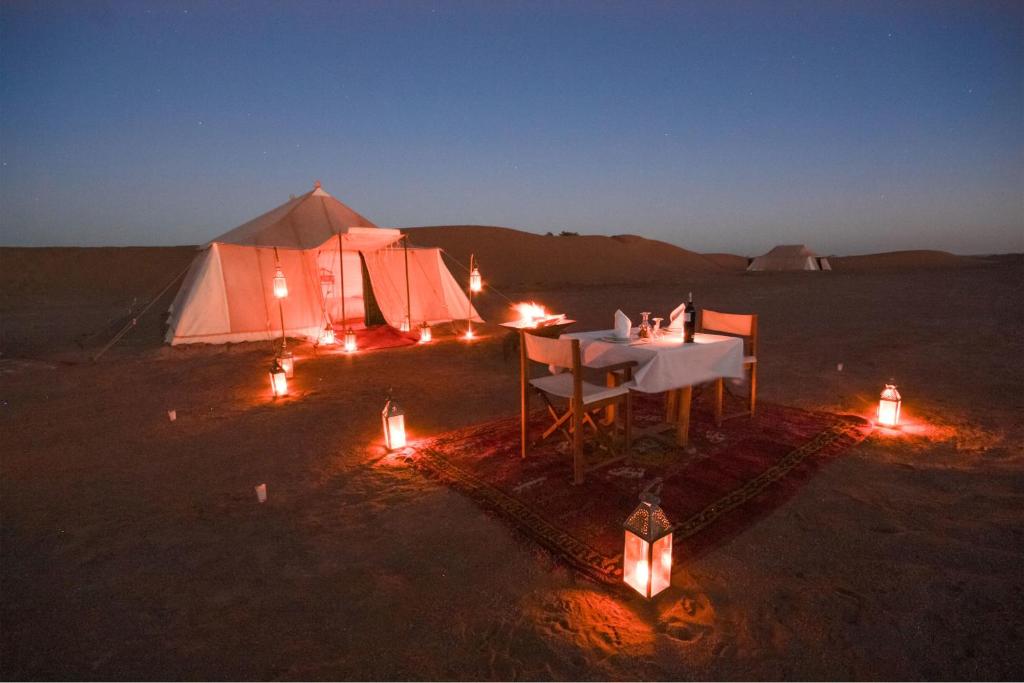 una tenda in mezzo al deserto con le luci di Bivouac de Luxe Le Pacha a M'Hamid
